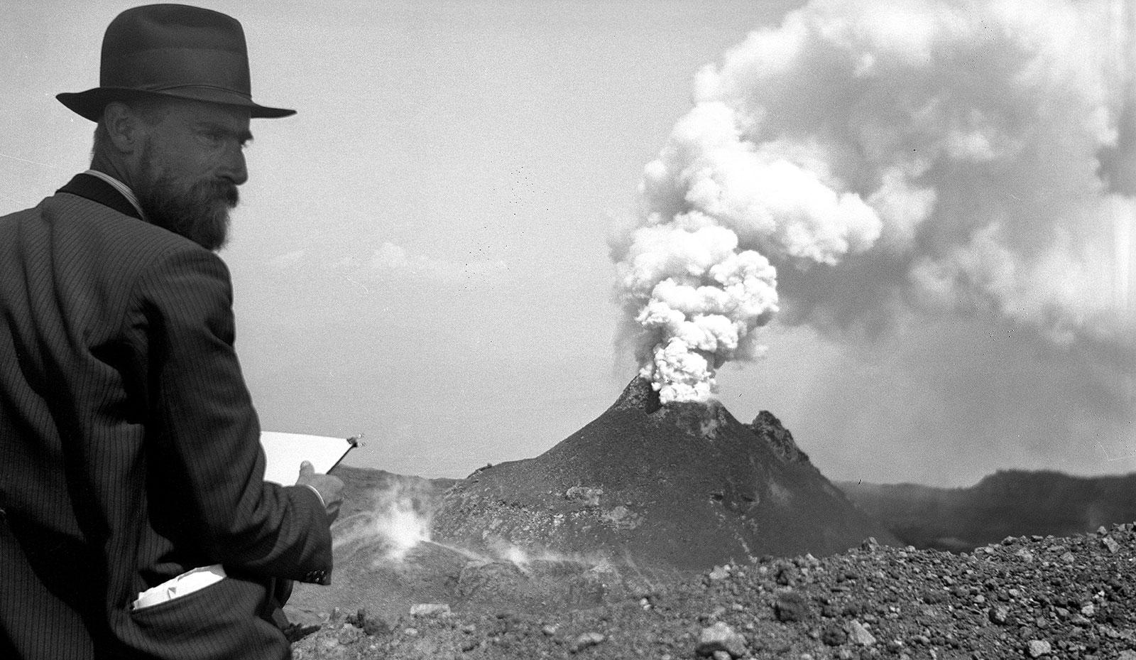 Escher, zittend met een schetsblok bij de Vesuvius, 30 mei 1934. Een berg die doet denken aan Mount Doom, de vulkaan uit The Lord of the Rings