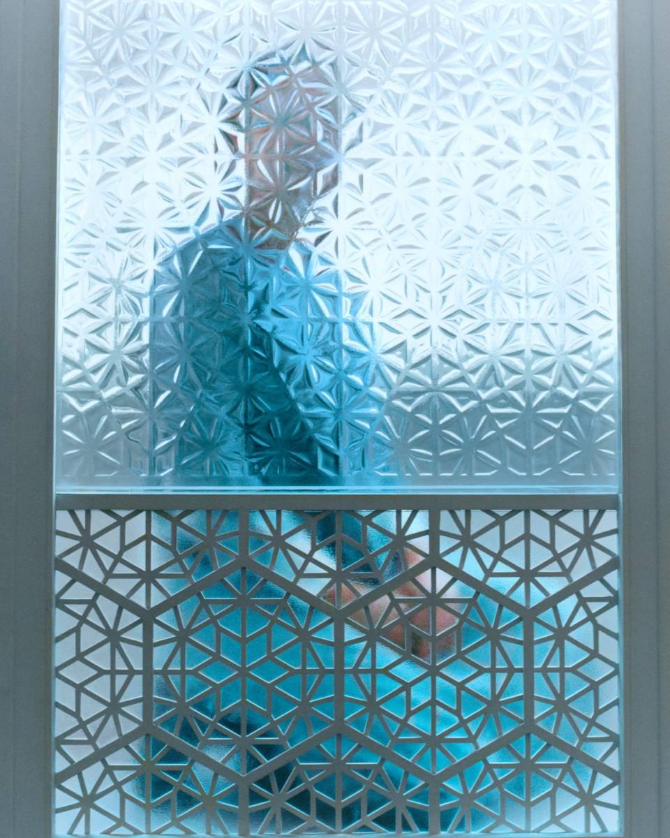 <p>Suleika Mueller, Nevine Nasser - The Sufi Architect, archiefpigmentafdrukken op fine art-papier, 2022<br><em>Bij Suleika Mueller wordt het concept perceptie zowel lichamelijk als persoonlijk. Haar werk doorgrondt hoe het voelt om bekeken te worden – als vrouw, als individu, als subject dat voortdurend wordt geïnterpreteerd. Ze bevraagt zo de kwetsbaarheid en de kracht van zichtbaarheid. Vanuit haar Sufi-achtergrond verkent Mueller hoe identiteit, spiritualiteit en menselijke verbinding vorm krijgen in architectuur en fotografie, waarbij geometrie een spirituele dimensie opent</em><br><br></p>