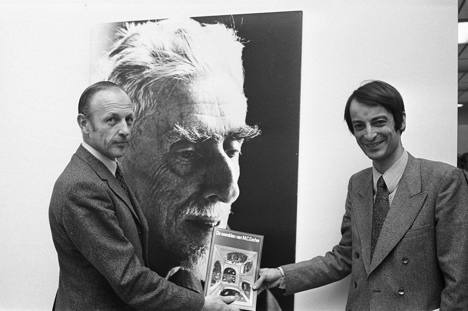 De eerste exemplaren van het boek worden uitgereikt in het Gemeentemuseum Den Haag, links J.L. Locher en rechts uitgever Van Hoorn, 23 november 1971. Collectie: Nationaal Archief